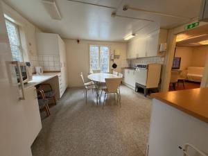 a kitchen and living room with a table and chairs at Workers Stay - Housing for Workers Olofstorp Göteborg in Olofstorp +12 photos