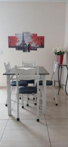 a white table and chairs with a picture on the wall at Quarto Casal Cinza in Artur Nogueira