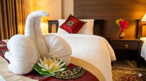 a hotel room with a towel animal on a bed at Valhalla Pattaya Hotel in Jomtien Beach