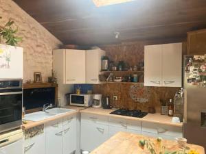 a kitchen with white cabinets and a counter top at Longère en campagne in Maisonnay