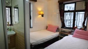 Habitación pequeña con 2 camas y lavamanos en Maple Leaf Guest House, en Hong Kong