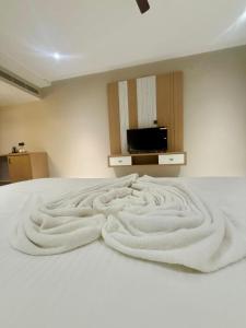 a bedroom with a white bed with a messed up blanket at Riviera Hotel and Resort in Choli