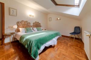 a bedroom with a large bed and a blue chair at Apartamento Bautista Centro in Cangas de Onís