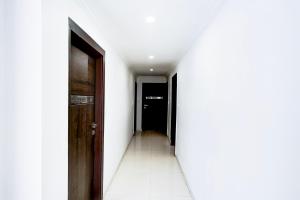 a corridor of a hallway with white walls and doors at Super Collection O Maninagar Formerly Park Land in Ahmedabad