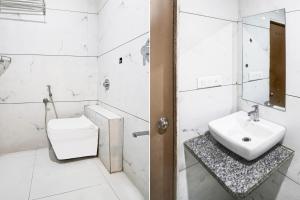 a white bathroom with a toilet and a sink at Super Collection O Maninagar Formerly Park Land in Ahmedabad