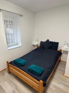 a bedroom with a large bed with two green pillows on it at Star Street Home in Mosonmagyaróvár