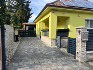 a yellow house with solar panels on it at Star Street Home in Mosonmagyaróvár
