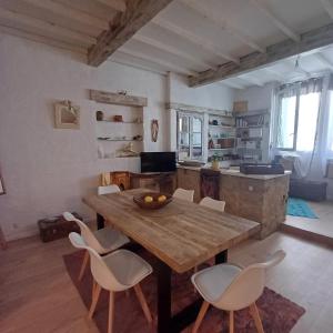 a kitchen and dining room with a wooden table and chairs at L'atelier d'LN in La Roque-dʼAnthéron