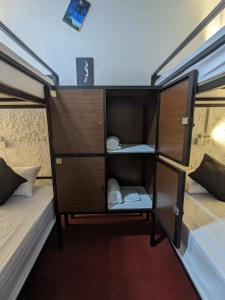 a small room with two beds and a bunk bed at Secret Surf Hostel in Weligama