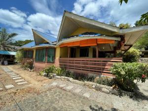 a house with a gambrel roof at 74YOU Beach Resort and Restaurant in Puerto Princesa City