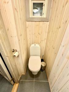 a small bathroom with a toilet and a window at Nordic Elegance Retreat in Sørvågen +24 photos