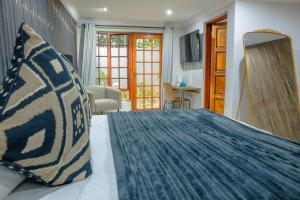 a bedroom with a large bed with a blue comforter at Apple Blossom Hotel Portfolio in Roodepoort
