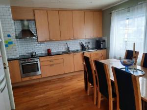 a kitchen with wooden cabinets and a table with chairs at Workers Stay - Housing for Workers Volvo Torslanda in Gothenburg