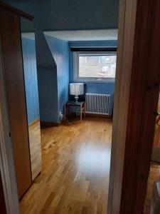 an empty living room with a window and a wooden floor at Workers Stay - Housing for Workers Volvo Torslanda in Gothenburg +2 photos