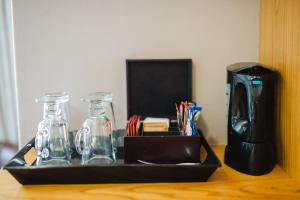 a tray with two glass bottles and a coffee maker at Kududu Guest House in Addo