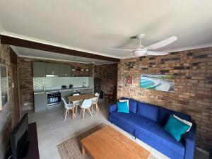 a living room with a blue couch and a table at Crescent Clearwater - Revival in Crescent Head