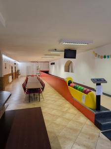 a waiting room with a table and a ping pong ball at Hotel Koloniál Skalité in Skalité