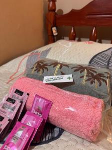 a pink towel on a bed with two pink products at Electra hospedaje familiar in Chicoana