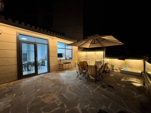 a patio with two chairs and an umbrella at 枫江月 in Fenghuang County