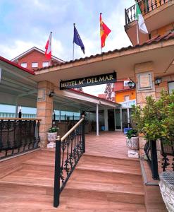 a hotel entrance with flags on a building at Hotel Maria del Mar in Noja