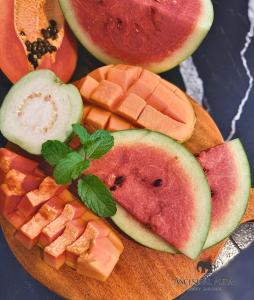 a wooden cutting board with slices of fruit on it at Ancestral Aura in Negombo +6 photos
