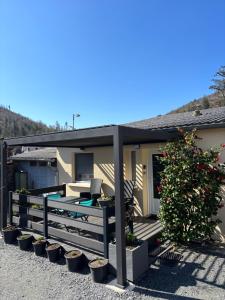 a house with a porch with a fence and plants at Le Refuge d'Helix in Viviez