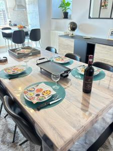 a wooden table with a bottle of wine on it at Maison villageoise in Anhée
