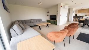 a living room with a couch and chairs and a table at Vakantiehuis Bartholomé in Nieuwmunster