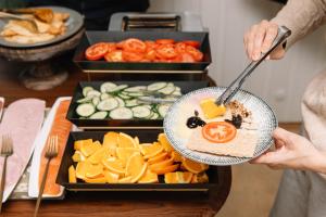 a person holding a plate of food on a table at Gjestehuset 102 - your home away from home! in Longyearbyen