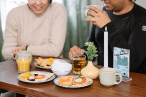 a man and woman sitting at a table eating breakfast at Gjestehuset 102 - your home away from home! in Longyearbyen
