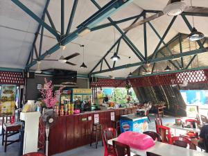 a restaurant with a bar and tables and chairs at Hosanna village in Semporna