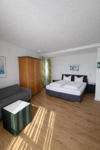 a bedroom with a bed and a couch at Hotel Klusenhof in Lippstadt