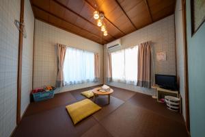 a living room with a table and a tv at Guesthouse SHELL in Naoshima