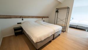 a bedroom with two beds and a mirror on the wall at Vakantiehuis Bartholomé in Nieuwmunster