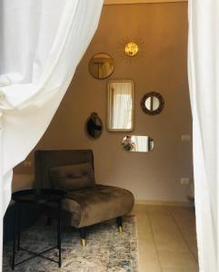a room with a chair and a mirror and a table at "Cuore Barocco" Hospitality in Noto in Noto