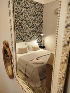 a bedroom with a bed with a mirror at "Cuore Barocco" Hospitality in Noto in Noto