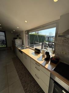 a kitchen with a counter and a large window at Maison villageoise in Anhée