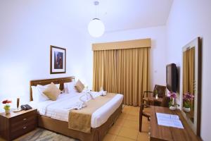 a hotel room with a large bed and a television at Tulip Hotel Apartments in Dubai +66 photos
