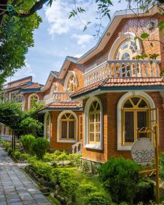 a brick house with a balcony on top of it at Park Village Resort by KGH Group in Kathmandu