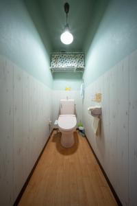 a bathroom with a white toilet and a sink at Guesthouse SHELL in Naoshima