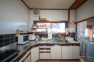 a kitchen with a sink and a counter top at Guesthouse SHELL in Naoshima +6 photos