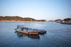 two boats are docked in a body of water at Guesthouse SHELL in Naoshima