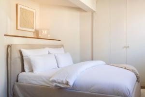 a white bed with white sheets and pillows at Boutique Charme Apartments Küferstr 10-12 in Baden-Baden