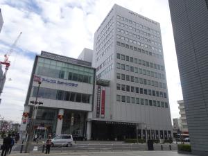 um edifício branco alto numa cidade em Hotel Toyota Castle em Toyota