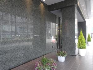豐田的住宿－豐田城堡酒店，建筑前有盆栽植物的建筑