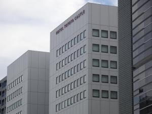 un edificio blanco alto con las palabras trilgrim en Hotel Toyota Castle, en Toyota