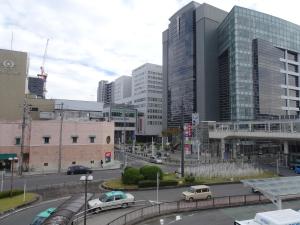 a city with cars on a street with buildings at Hotel Toyota Castle in Toyota