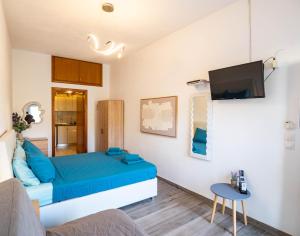 a living room with a blue bed and a tv at Doukas Apartments & Studios in Skala Marion