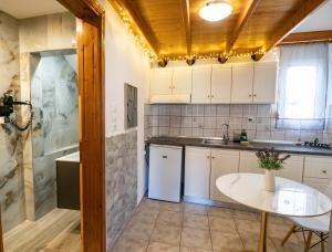 a kitchen with a table and a white refrigerator at Doukas Apartments & Studios in Skala Marion +180 photos