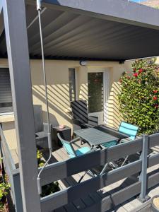 a patio with chairs and a table on a deck at Le Refuge d'Helix in Viviez